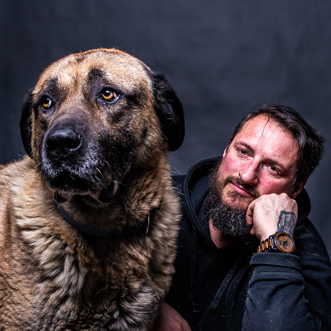Gerd Schuster mit einem großen Hund neben sich